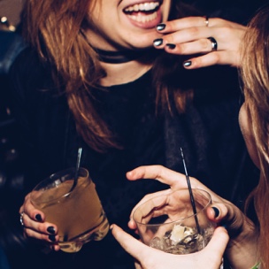 women with drinks laughing